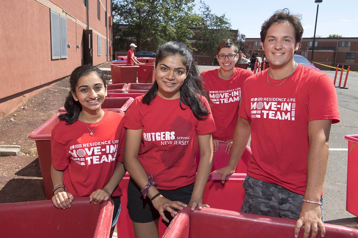 Four students wear red T-shirts for the "Move-In Team" that is part of Rutgers support services. 
